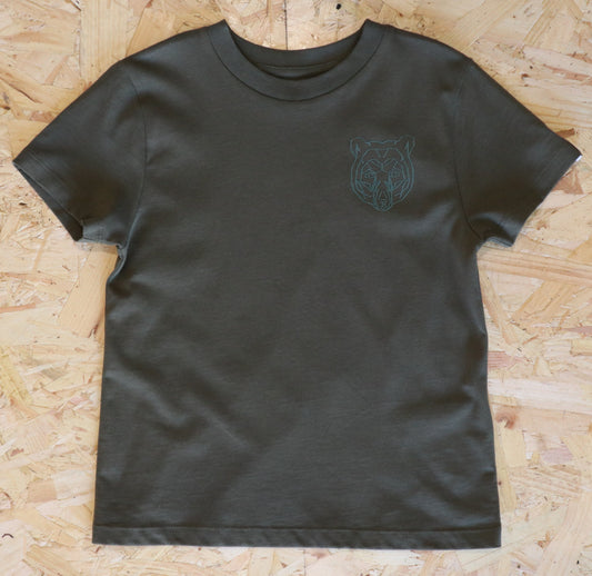 Khaki  t-shirt with a green bear logo on a wooden surface